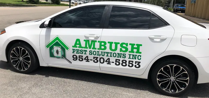 Branded Ambush Pest Solutions truck loaded with spray equipment parked at a Coconut Creek job site